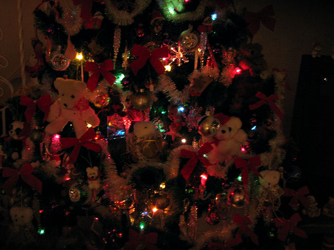 Closer photo of Christmas tree decorated with bears all lit up